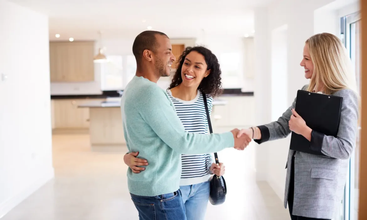 Happy couple shaking hands with Space Coast realtor after successful home purchase