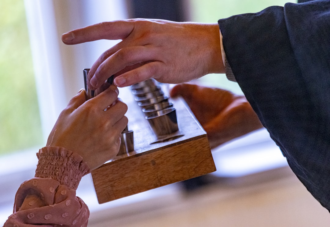 A diverse group of hands works together to fit the final puzzle pieces into place on a clean table, symbolizing collaboration and community problem-solving.