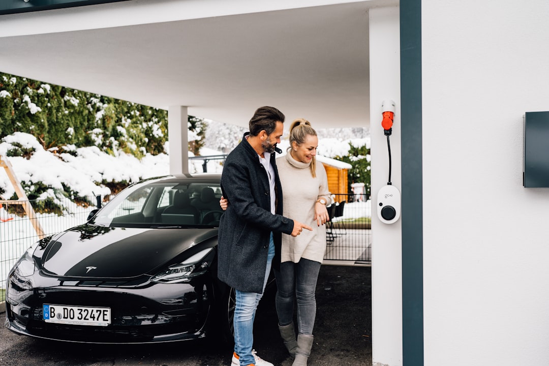 A smiling, happy couple stands in front of a modern home, holding up a set of keys, symbolizing the successful sale of their property and maximization of their home equity.