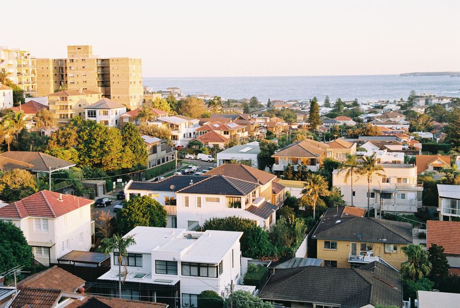 View from the balcony of a modern, high-end home looking out over a tranquil blue ocean, evoking a sense of paradise.